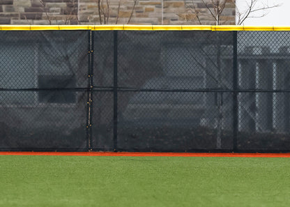Fencemate windscreen - Black chain-link fence with a yellow top section on a sports field.