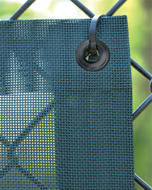 Fencemate windscreen - Green mesh screen with a metal clip on a wire frame against a blurred green background