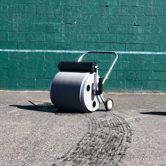 Detail view of the Super Sopper water roller showing the 14-gallon water removal drum, squeeze roller mechanism, and drain elbow.
